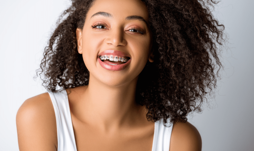Smiling young woman with dental braces displaying her bright teeth.